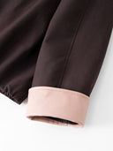 Close-up of the cocoa-brown fabric and smooth blush-pink contrast cuff