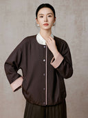Close front view of the jacket showing the snap closure, side pocket and contrast cuffs