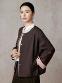 Three-quarter model view showing the jacket’s relaxed sleeves and pink cuff detail