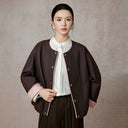 Model wearing the cocoa-brown jacket open over a white blouse