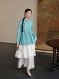 Full look of the cooling blue mulberry silk Hualuo shirt styled with a white lace skirt and silver shoes
