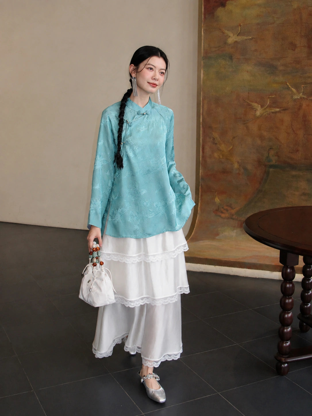 Full look of the cooling blue mulberry silk Hualuo shirt styled with a white lace skirt and silver shoes