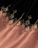 Close-up of gold-toned geometric beadwork where the black velvet meets the sheer brown hem