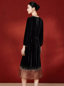 Three-quarter back view showing the dress’s waist tie and sheer brown hem
