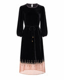 Product-only front view of the black velvet dress with balloon sleeves and a copper-toned hem