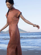 Side view of a coral silk blend Chinese style maxi dress featuring a mandarin collar and side slit.