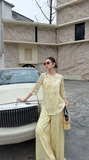 Side view of a cream yellow Qipao blouse and palazzo pants set, featuring floral jacquard texture and a relaxed fit.