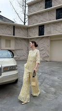Full body shot of a cream yellow co-ord set, featuring a short-sleeve Qipao top and matching wide-leg trousers.