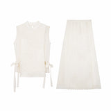 Flat lay of a cream white Cheongsam vest and matching midi skirt set, featuring geometric embroidery, side ties, and a scalloped hem.