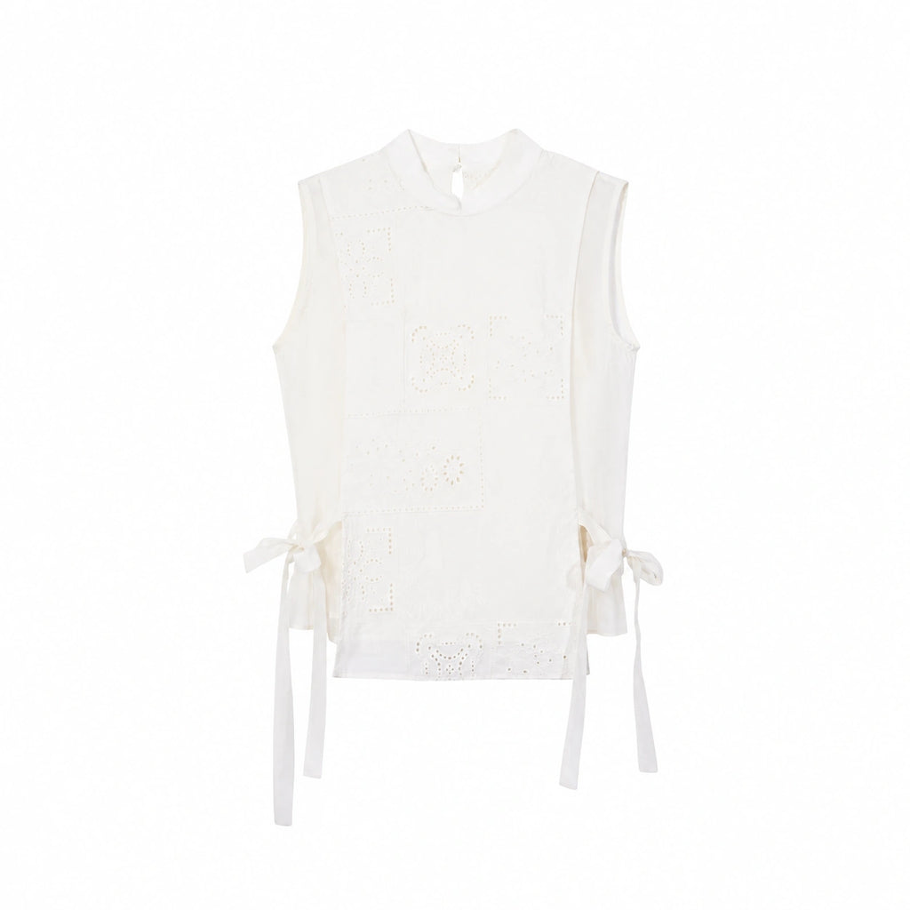 Flat lay of a cream white sleeveless Cheongsam vest with geometric embroidery, side ties, and a front button closure.