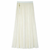 Flat lay of a cream white shiny pleated maxi skirt with elastic waistband and side tassel tie, crafted from 100% polyester.