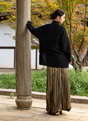 Back view of the Jinyu Black shirt worn with a gold skirt.