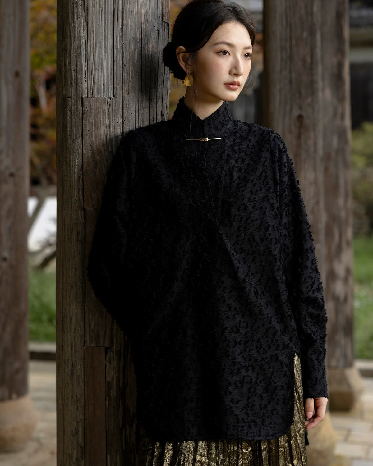 Model wearing the Jinyu Black textured shirt with a gold-tone collar closure.