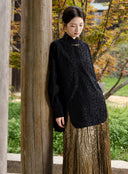 Model wearing the Jinyu Black textured shirt with a metallic gold skirt.
