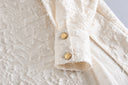 Close-up of the Ningzhi Ivory shirt’s textured fabric and gold-tone cuff buttons.