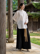 Full-length look of the Ningzhi Ivory shirt paired with a black skirt.