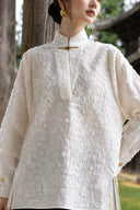 Close view of the Ningzhi Ivory shirt worn by a model, highlighting its textured front.