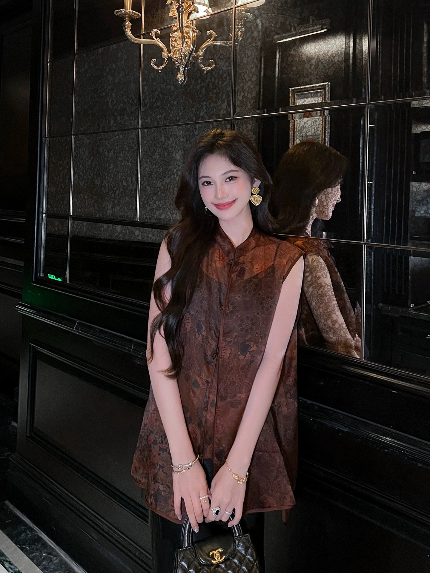 Woman wearing a Dark Walnut Brown jacquard Mulberry Silk sleeveless vest styled with a flowing black skirt.