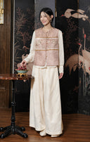 Full-length view of the rose jacquard vest styled with a cream blouse and long skirt.