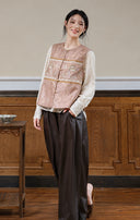 Model wearing the loose-fit rose jacquard vest with a cream blouse and brown trousers.