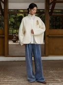 Ivory Duyao V-neck wool coat styled over a white blouse with blue wide-leg trousers