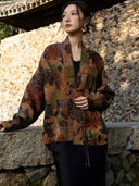 Front view of an earth brown printed jacket with olive and black motifs, a broad neckline band and cord-loop detailing.
