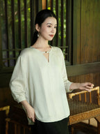 Lifestyle portrait featuring an embroidered V-neck blouse with a relaxed silhouette.