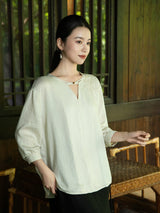 Lifestyle portrait featuring an embroidered V-neck blouse with a relaxed silhouette.