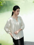 Side profile of a relaxed embroidered viscose linen blend blouse.
