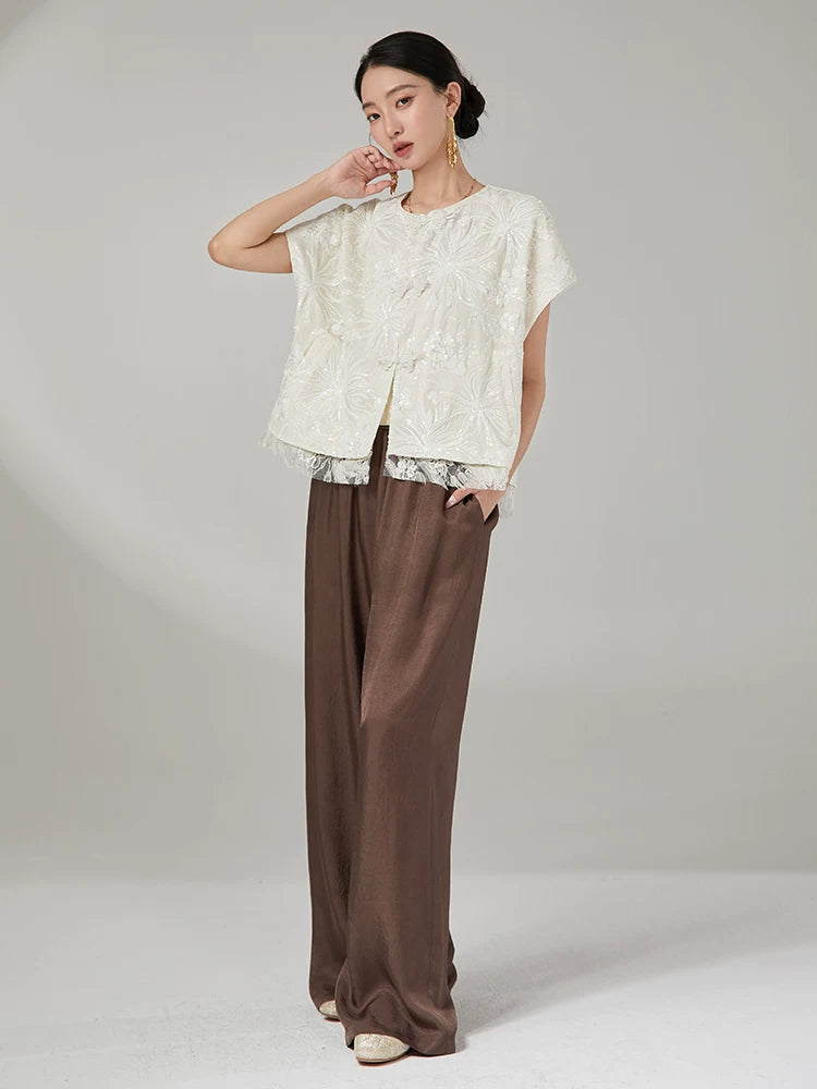 Lifestyle look featuring an embroidered floral jacket with elegant wide-leg pants.