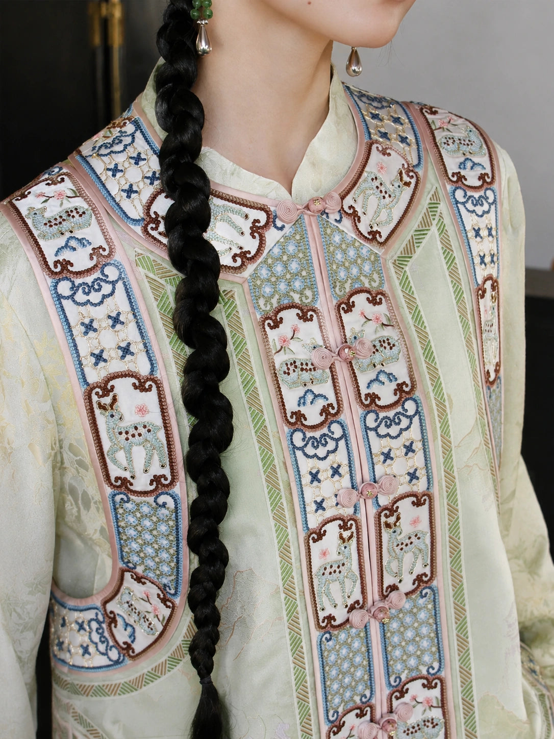Close-up of the vest’s embroidered floral panels, decorative buttons, and colorful traditional-inspired motifs.