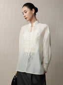 Side view of a lightweight embroidered lyocell linen blend blouse with a relaxed silhouette.