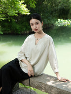 Women's embroidered blouse styled outdoors beside a peaceful lake.