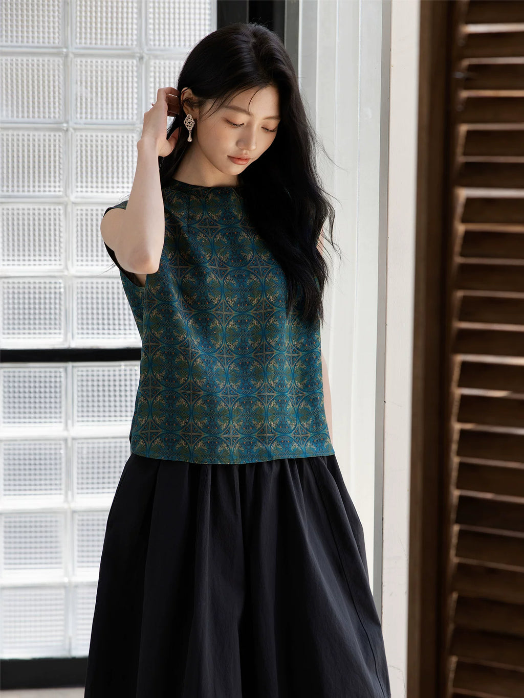 Close-up of an emerald mulberry silk blouse showing the geometric woven pattern.