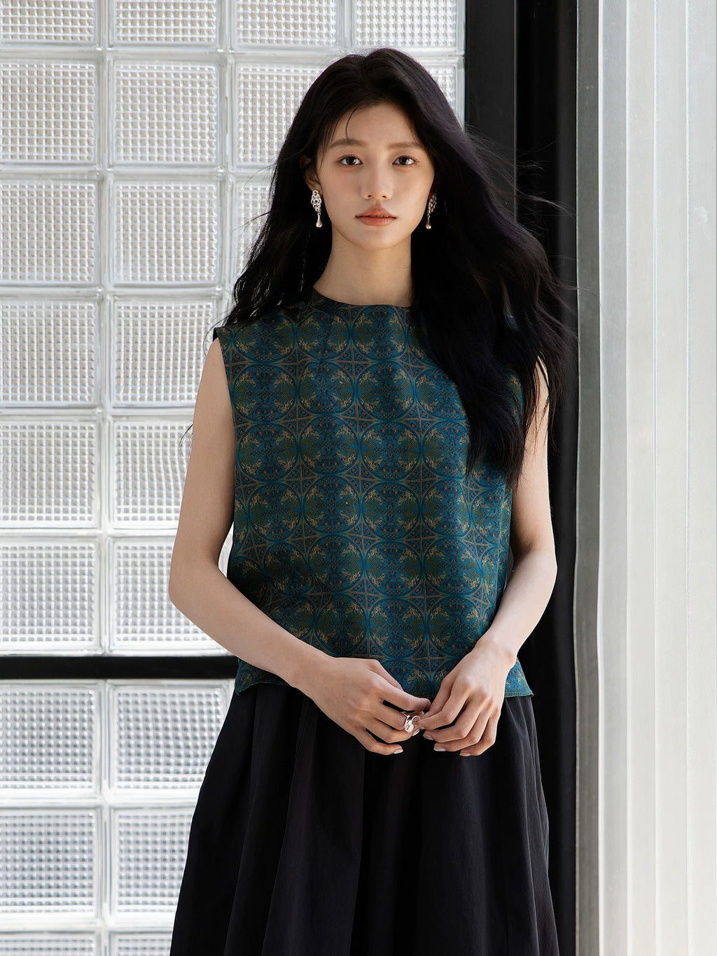 Front view of an emerald green sleeveless mulberry silk blouse with geometric print.