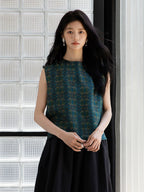 Front view of an emerald green sleeveless mulberry silk blouse with geometric print.