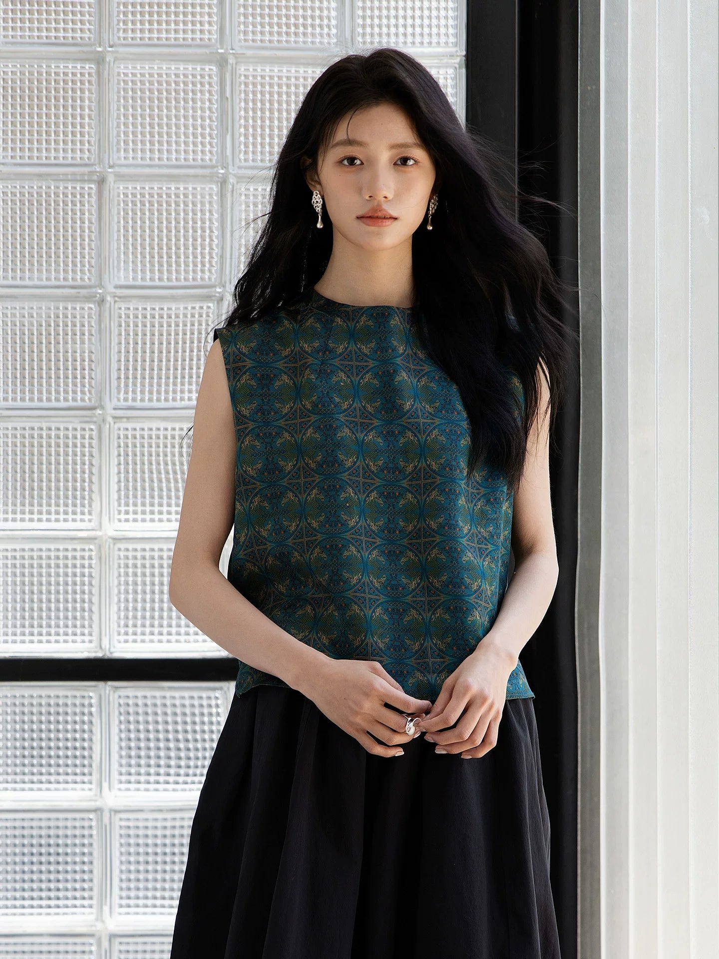 Front view of an emerald green sleeveless mulberry silk blouse with geometric print.