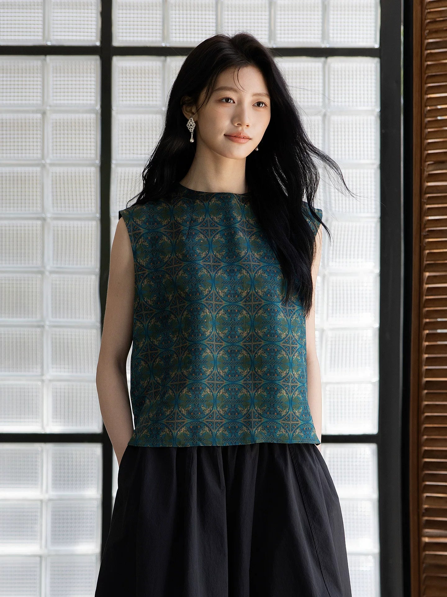 Relaxed fit emerald silk blouse styled with a minimalist black skirt.