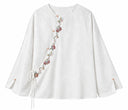 Front view of the blouse with a diagonal embroidered closure and side tie