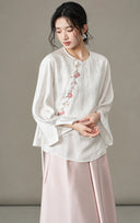 Model wearing the white jacquard blouse with a pale pink skirt, angled view