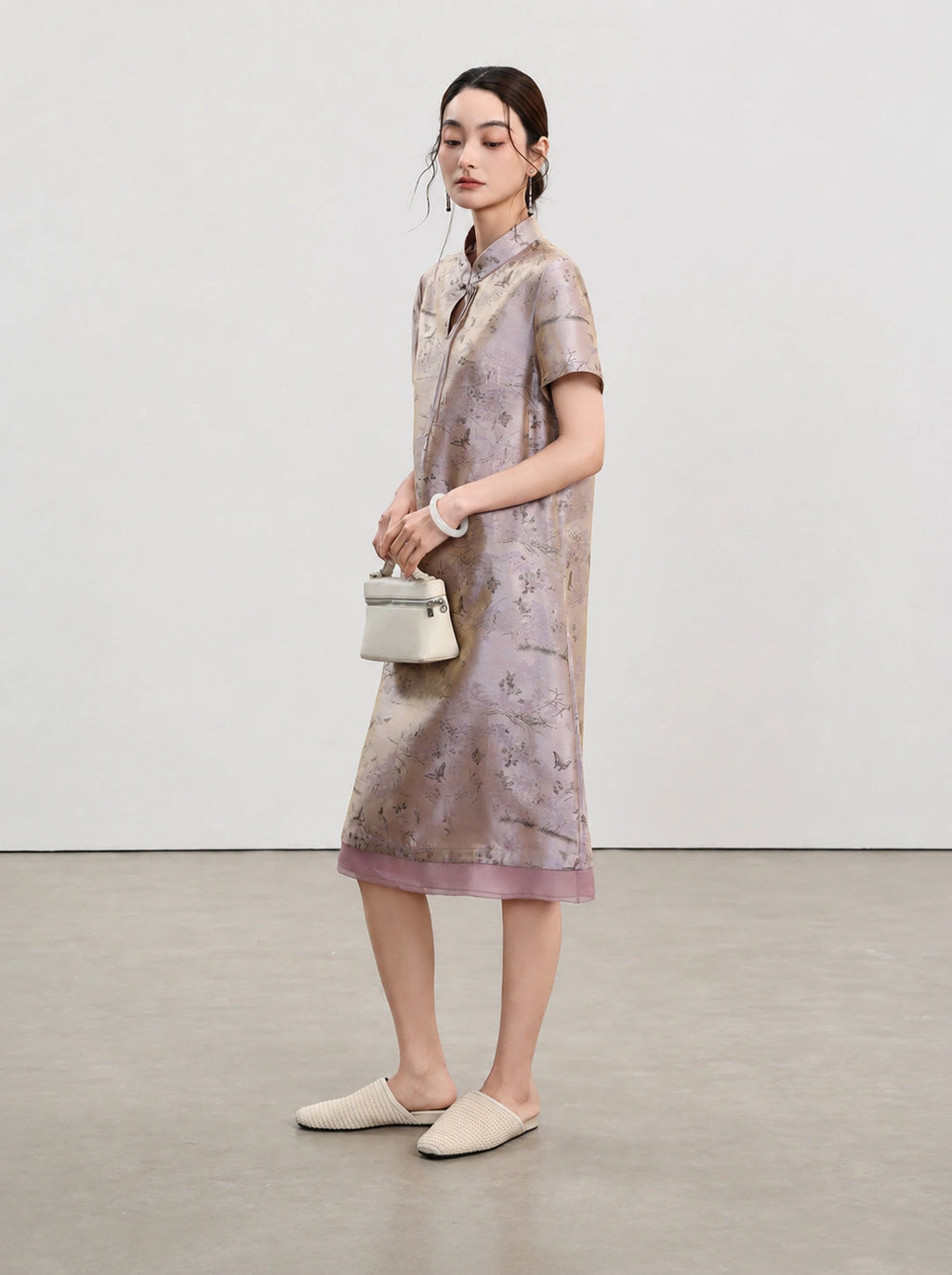 Side view of the light lavender A-line qipao with short sleeves and contrasting sheer hem