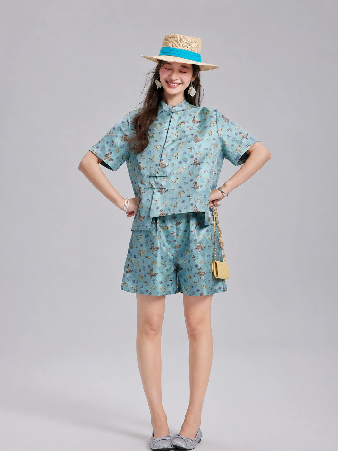 Model wearing an aqua Shu brocade short-sleeve shirt and coordinating silk shorts.