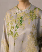 Close-up of the round neckline, asymmetric placket and green button on the botanical silk blouse