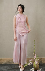 Front view of a fitted blush-pink cut-velvet vest with asymmetric frog buttons and side ties