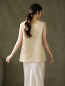 Back view of the relaxed sleeveless vest with an all-over gold Baoxiang floral pattern