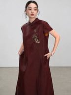 Three-quarter view showing the bronze beaded embroidery and side pockets of the Xiangyunsha dress