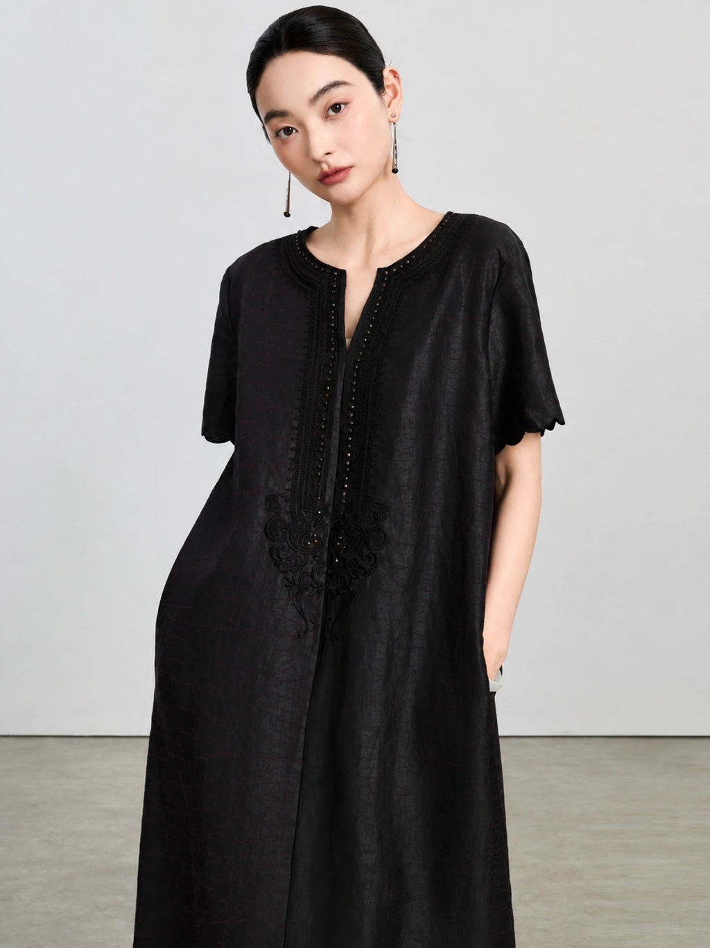 Upper-body view of the embroidered V-neck, bead accents and subtle tortoiseshell texture