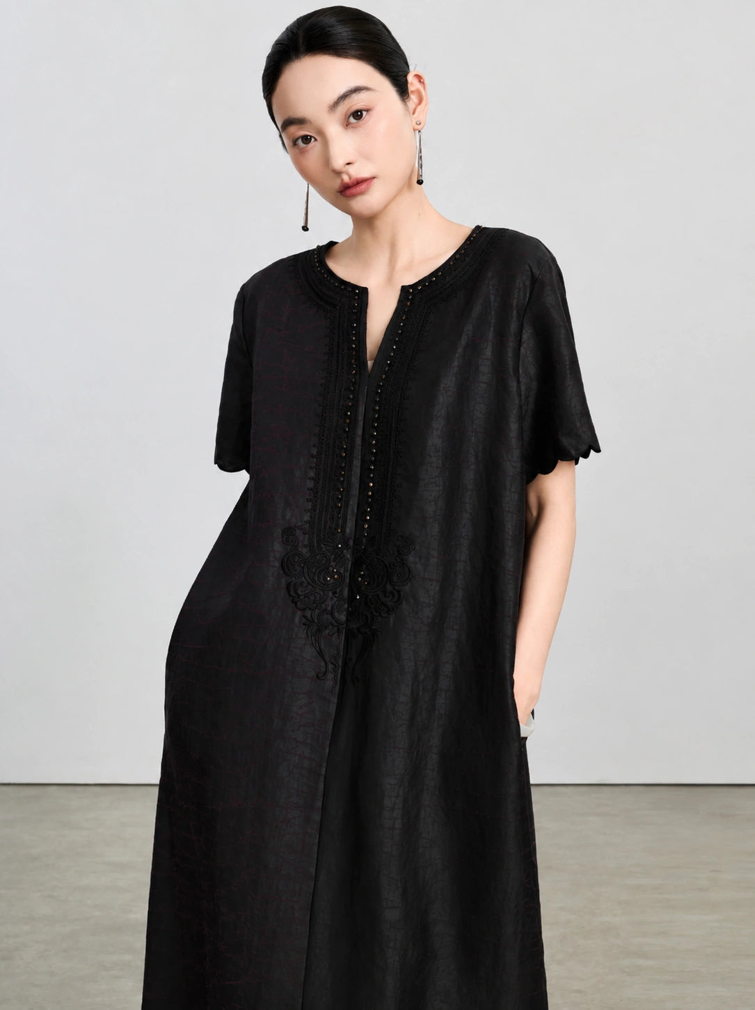 Upper-body view of the embroidered V-neck, bead accents and subtle tortoiseshell texture