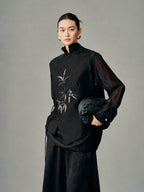 Model wearing the black wool-silk vest with beaded bamboo embroidery and an asymmetric wrap front