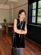 Model styling a long black Chinese-inspired silk-blend top with contrasting pink edging